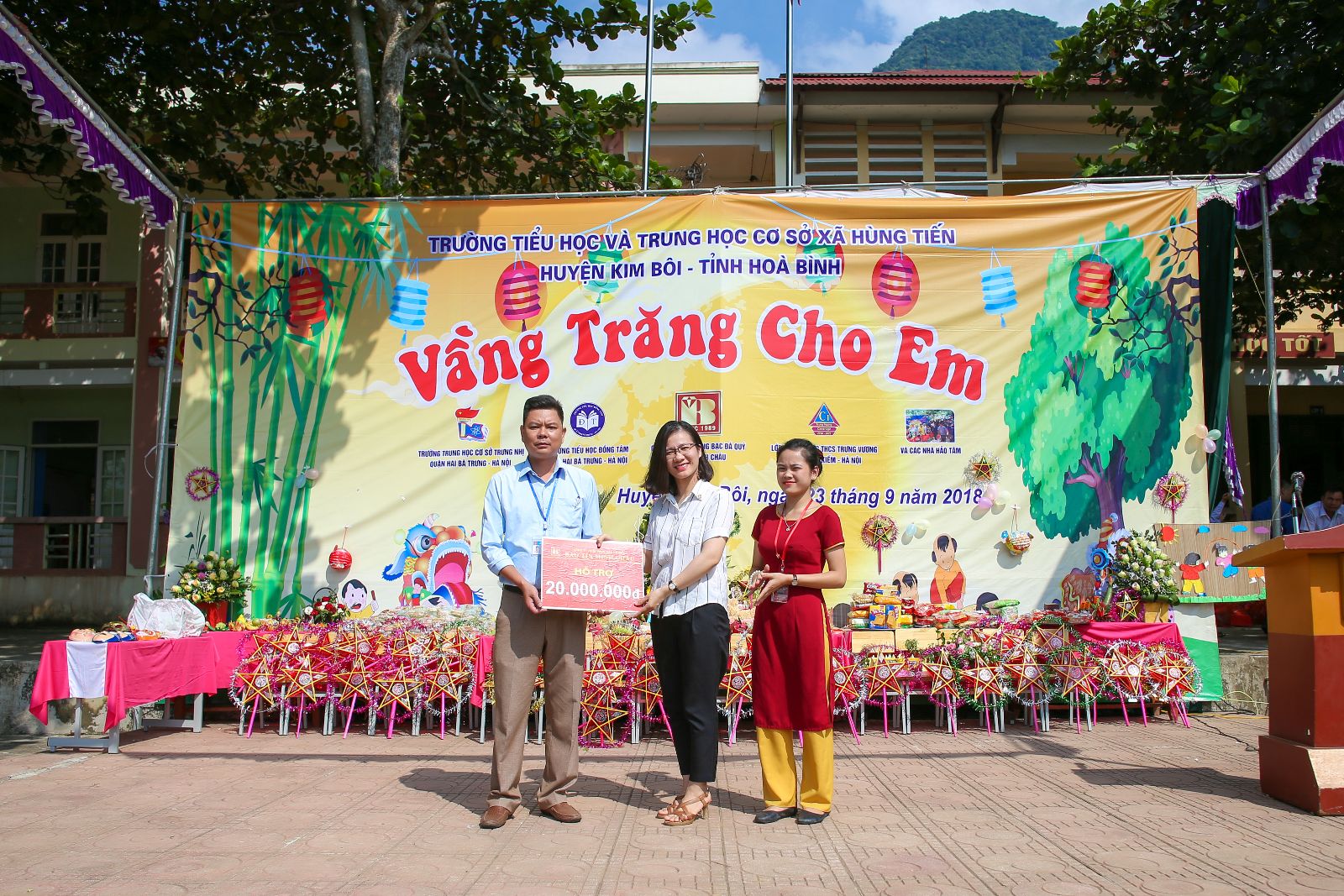 Bà Trần Cẩm Vân đại diện công ty Bảo Tín Minh Châu tặng quà cho các em học sinh xã Hùng Tiến